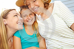 Enjoying the warm summer day together. A cute young girl spending time in the summer sun with her mother and grandmother