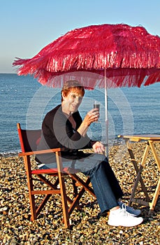 Enjoying wine on beach under parasol