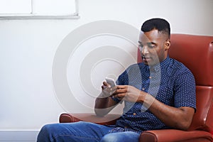 Enjoying wireless freedom. A handsome young woman sitting on a sofa with a wireless device.