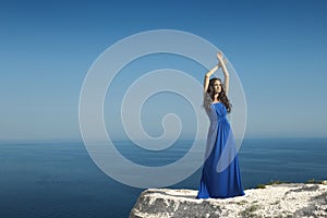 Enjoyment. Fashion Happy beautiful woman with dress over blue sk photo