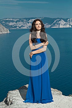 Enjoyment. Fashion Happy beautiful woman in long dress over blue