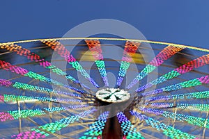 Enlighted giant wheel in motion, at sunset