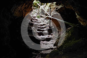 Enlighted lava tunnel with humid floor in the Galapagos island of Sand Cruz on the way to Puerto Ayora, Ecuador