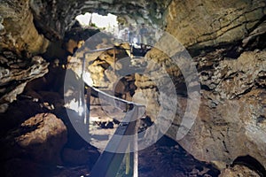 Enlighted lava tunnel with humid floor in the Galapagos island of Sand Cruz on the way to Puerto Ayora, Ecuador