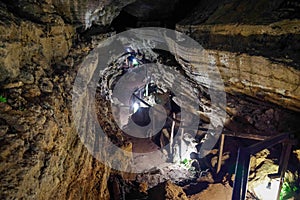 Enlighted lava tunnel with humid floor in the Galapagos island of Sand Cruz on the way to Puerto Ayora, Ecuador