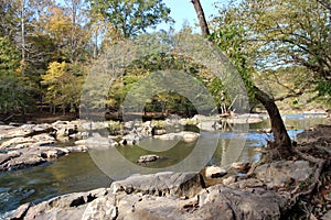 The Eno River flowing over boulders through a forest in Durham, North Carolina