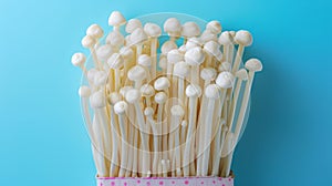 Enoki mushroom, flammulina velutipes, arranged on a soft and elegant pastel colored background
