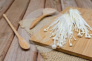 Enoki mushroom with spoon on wooden table