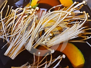 Enoki Mushrooms and Sliced Pumpkins in Black Shabu Soup