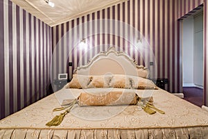 Enormous bed inside baroque bedroom photo