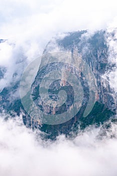 Enormous cliffs, shrouded in early morning fog and mist