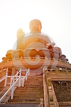 The enormous Tian Tan Buddha at Po Lin Monastery in Lantau Island, Hong Kong. Photographed during sunset with orange sun shining