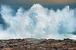 An enormous wave crashing against the rocks at Storms River Mouth, South Africa