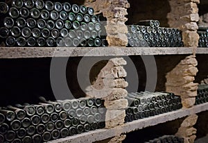 Enoteca. Wine collection in a wine cellar. Dottles on a rack closeup photo