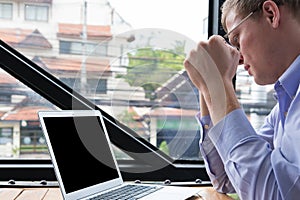 Enraged businessman look at laptop. angry young man holding his