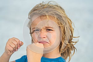 Enraged kid boy with angry expression. Angry hateful little anger boy, child furious. Angry rage kids face closeup