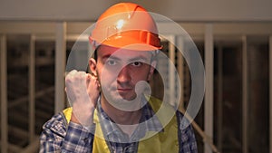 Enraged nervous worker or an engineer is threatens someone with his fist and is making an admonition