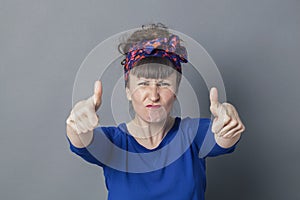 Enraged woman frowning with thumbs up for fighting success