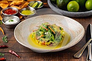 Ensalada de aguacate with various sauces on wooden table