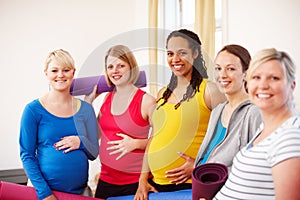 Ensuring a healthy and happy pregnancy. A multi-ethnic group of pregnant women holding their exercise mats in a gym.