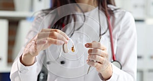 ENT doctor holds hearing aid in hands