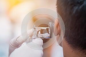 ENT physician checking patient& x27;s ear using otoscope with an inst