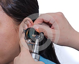 ENT physician checking patient's ear using otoscope with an inst