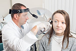 ENT physician looking into patient`s ear with an instrument. private clinic. otolaryngologist