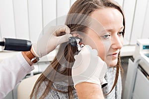 ENT physician looking into patient`s ear with an instrument. private clinic. otolaryngologist