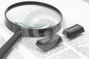 Enter and Backspace Computer Keys and a Lens on a Book Page