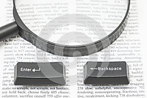 Enter and Backspace Computer Keys and a Lens on a Book Page