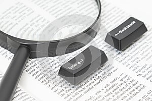 Enter and Backspace Computer Keys and a Lens on a Book Page
