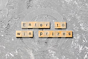 Enter to win prizes word written on wood block. Enter to win prizes text on cement table for your desing, Top view concept