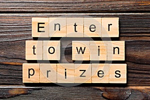 Enter to win prizes word written on wood block. Enter to win prizes text on wooden table for your desing, Top view concept