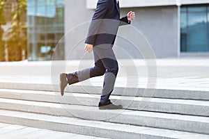 Enterpreneur in formal wear rushing up stairs, being late for work at city center, close up of legs