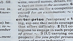 Enterprise, pencil pointing word in dictionary, engaging in business activity