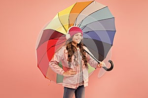 Entertain yourself. Fun concept. Feeling good. Girl having fun walking wireless headphones under colorful umbrella. Fall