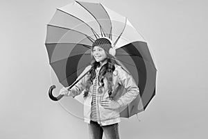 Entertain yourself. Fun concept. Feeling good. Girl having fun walking wireless headphones under colorful umbrella. Fall