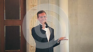 Entertainer leads event speaks into the microphone gesturing