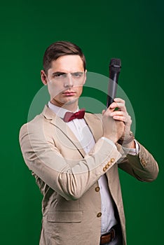 The entertainer. Young elegant talking man holding microphone, Isolated in studio