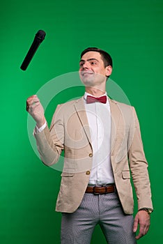 The entertainer. Young elegant talking man holding microphone, Isolated in studio