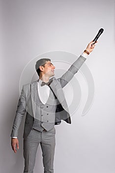 The entertainer. Young elegant talking man holding microphone, Isolated in studio