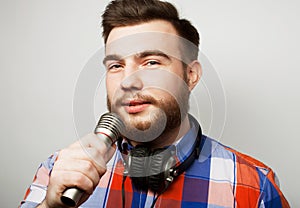 The entertainer. Young talking bearded man holding microphone.