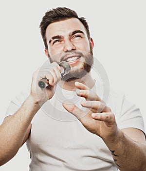 The entertainer. Young talking man holding microphone, Isolated on white background.