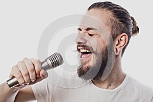 The entertainer. Young talking man holding microphone, Isolated on white background.