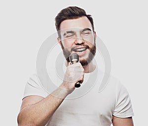 The entertainer. Young talking man holding microphone, Isolated on white background.