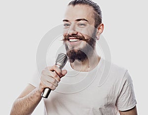 The entertainer. Young talking man holding microphone, Isolated on white background.