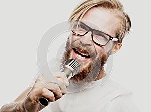 The entertainer. Young talking man holding microphone, Isolated on white background.