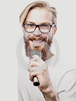 The entertainer. Young talking man holding microphone, Isolated on white background.