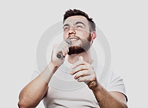 The entertainer. Young talking man holding microphone, Isolated on white background.